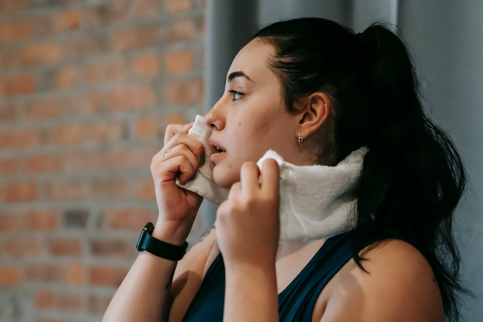 體味的主要來源
Side view of a woman wiping sweat with a towel after exercising indoors.